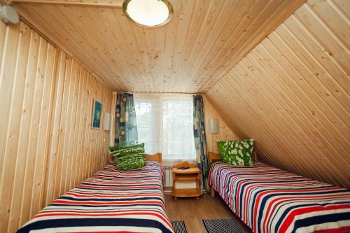 two beds in a room with wooden walls at Baza otdikha Ekaterininskaya Sloboda in Sloboda