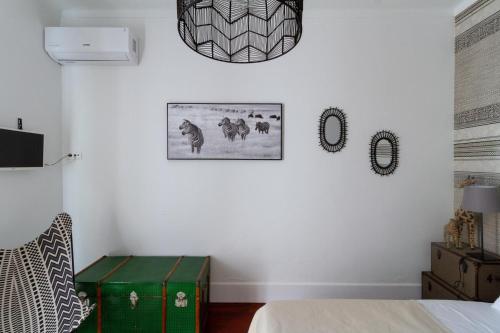 a bedroom with a bed and a green trunk at Santo António's Guesthouse in Cascais