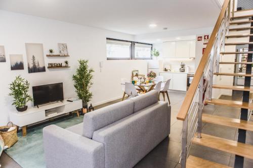 a living room with a couch and a tv at Casa Alivas in Furnas