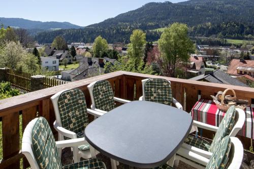 a table and chairs on a balcony with a view at Haus Sonnseitn Murau für 6 bis 8 Personen in Sankt Egidi