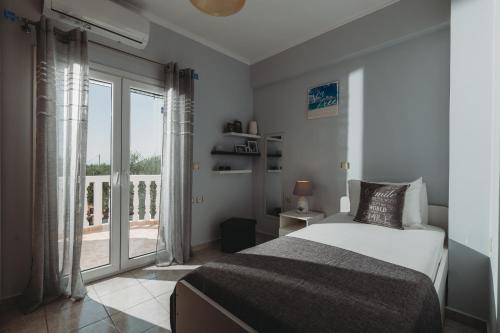1 dormitorio con cama y ventana grande en Villa Rosa 3 Bedroom with Sea View en Tragaki