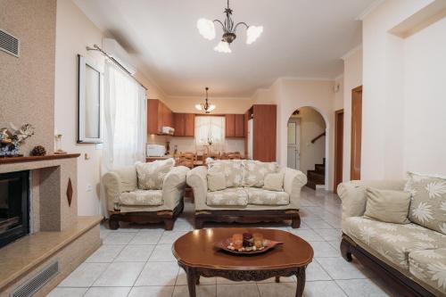 a living room with two couches and a table at Villa Rosa 3 Bedroom with Sea View in Tragaki