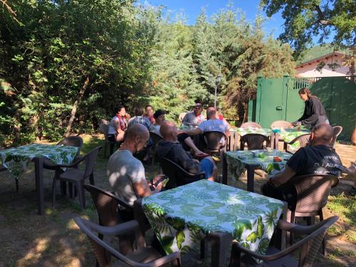 a group of people sitting at tables in a yard at Antico Borghetto - Casa Vacanze in Norcia