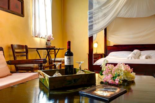 a room with a bed and a table with a bottle of wine at Elia Hotel & Spa in Áno Voúvai
