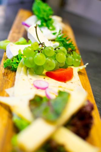 a cutting board with grapes and other vegetables on it at Gasthaus & Hotel Drei Lilien in Werbach