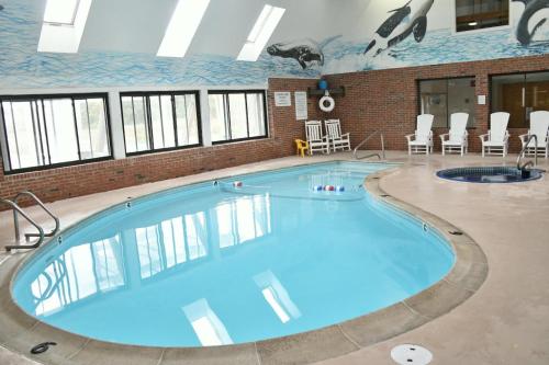 a large swimming pool with blue water in a building at Pilgrim Sands on Long Beach in Plymouth