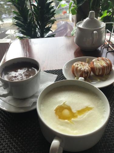 a table with a bowl of soup and a plate of donuts at Hotel Kavkaz in Arkhyz