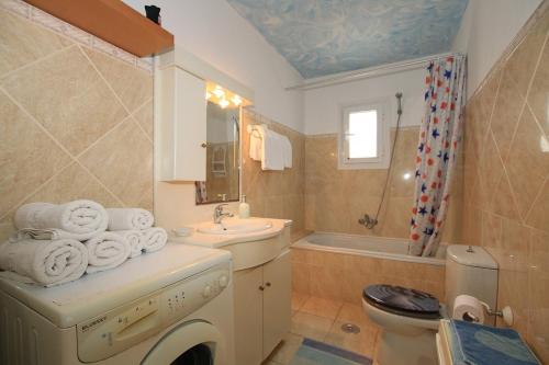 a bathroom with a sink and a washing machine at VILLA ERMIONI in Melíkia