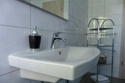 ein weißes Waschbecken im Bad mit Spiegel in der Unterkunft Margaréta Panzió in Budakeszi
