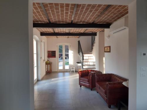 a living room with leather furniture and a coffered ceiling at SANTA MARIA DI LORGANA in Minerbio