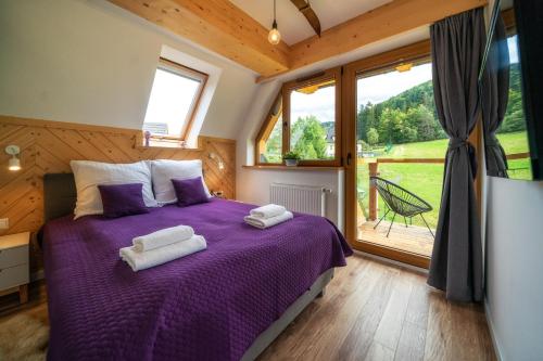 ein Schlafzimmer mit einem lila Bett mit Handtüchern darauf in der Unterkunft Nosal Apartment in Zakopane