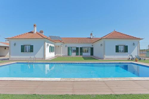 a large swimming pool in front of a house at Quinta da Pinheira Lezíria in Alpiarça
