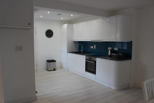 a kitchen with white cabinets and black appliances at The Annexe in Ditcheat in Ditcheat
