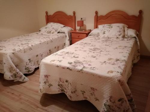 1 dormitorio con 2 camas y mesa con lámpara en Apartamento Millas, en San Juan de Plan