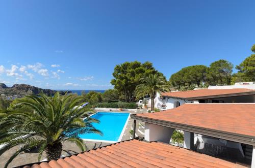 a villa with a palm tree and a swimming pool at Villa dei Sogni in Vulcano