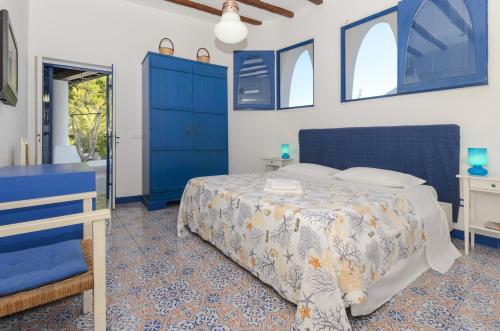 a blue bedroom with a bed and blue cabinets at Villa dei Sogni in Vulcano