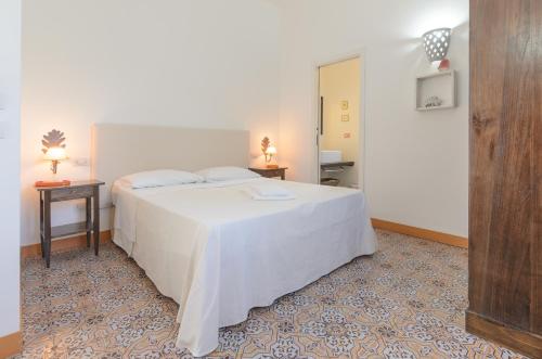 a bedroom with a large white bed and two tables at Villa dei Sogni in Vulcano