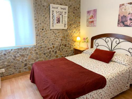 Un dormitorio con una cama con una almohada roja. en Alto Palancia Calle Progreso 25 Sot de Ferrer, en Sot de Ferrer