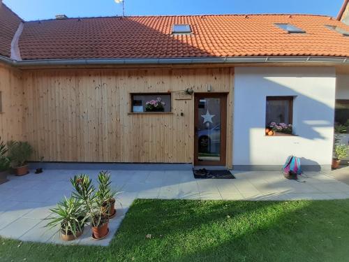 ein Haus mit einem Holzzaun und einer Tür in der Unterkunft Vidiecky apartmán Kubo in Pavčina Lehota