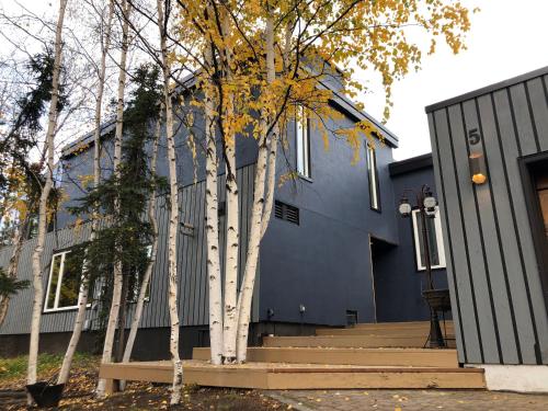 a blue house with trees in front of it at 好丘。Hacho House in Yellowknife