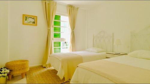um quarto de hotel com duas camas e uma janela em Viñas by Villas Rinamar em Playa de las Americas