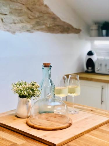 two wine glasses and a bottle on a cutting board at The Clock Tower Stow in Stow on the Wold