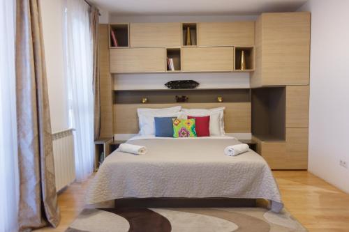 um quarto com uma grande cama branca com almofadas coloridas em Presecan One Room Apartment with view em Cluj-Napoca