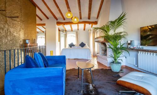 a living room with a bed and a blue couch at El Palauet del Priorat in Cornudella