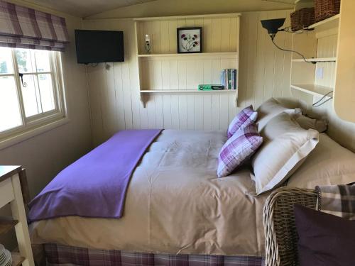 Una cama o camas en una habitación de The Hawthorn Shepherds Hut