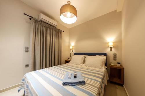 a bedroom with a bed with a pair of slippers on it at San Marco Elegant Apartment Zante in Zakynthos
