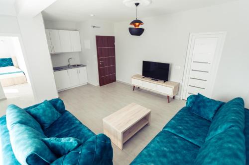 a living room with a blue couch and a table at CITY HOTEL in Ferizaj