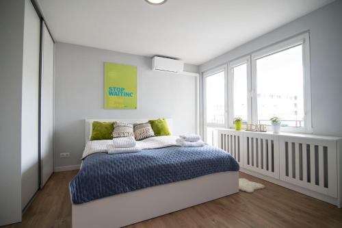 - une chambre avec un lit et une couette bleue dans l'établissement WLR Apartments - Hoza II, à Varsovie