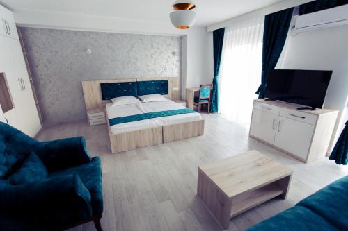 a bedroom with a bed and a tv and a couch at CITY HOTEL in Ferizaj
