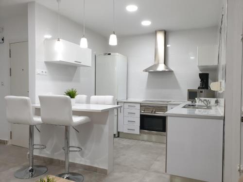 eine weiße Küche mit weißen Geräten und weißen Schränken in der Unterkunft Centre Apartment near Plaza de Toros in Alicante