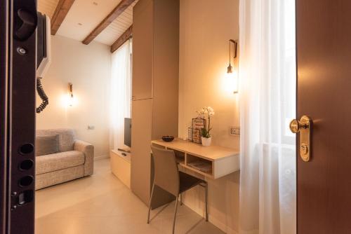 een kleine kamer met een bureau en een bank bij Dreamy apartment Tre Corone Old Town CIR 017067-CNI-00565 in Desenzano del Garda