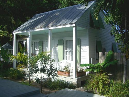 a white house with a porch with plants at Bahama Gardens - Conch House in Key West