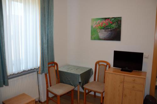 a room with a table and chairs and a television at Zimmervermietung Fasching in Sankt Pölten