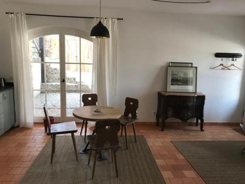 a dining room with a table and chairs and a piano at Ferienhaus am Schloss Meseberg in Meseberg