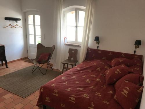 a bedroom with a red bed and two windows at Ferienhaus am Schloss Meseberg in Meseberg
