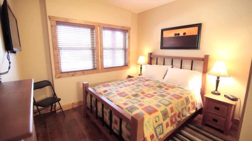 a bedroom with a bed and a chair and a window at Casa Del Mila Oro Condo in Osoyoos