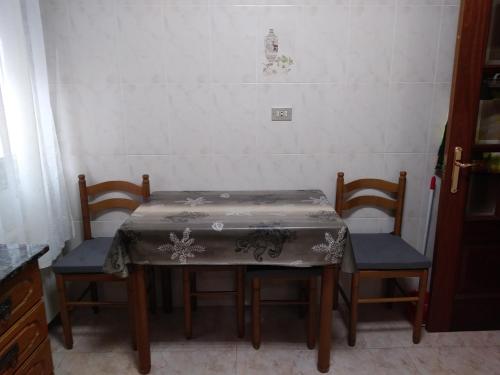 een tafel en twee stoelen met een tafelkleed erop bij Apartamento La Villa in Portugalete