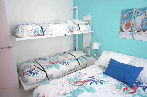 1 dormitorio con 2 literas y pared azul en Apartment Covelo, en Samieira