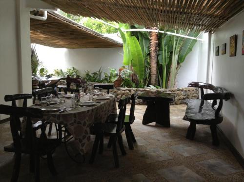a dining room with a table and chairs and plants at Balay Tuko Garden Inn in Puerto Princesa City