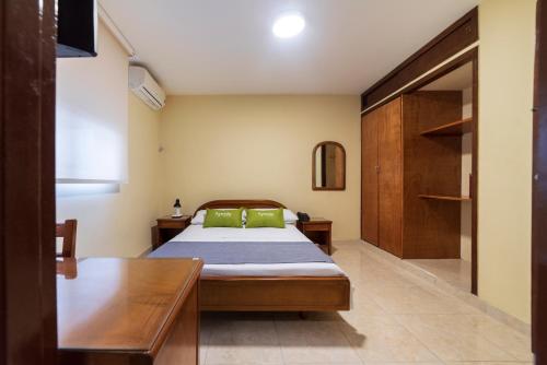 a bedroom with a bed with green pillows at Ayenda 1502 Principe in Bucaramanga
