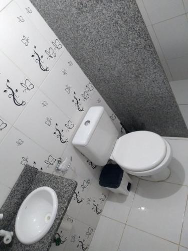 a bathroom with a white toilet and a sink at Bosque dos Esquilos in Abraão