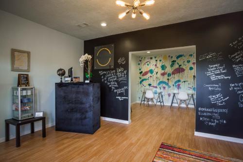 a room with a chalkboard wall with a table and chairs at Wanderstay Houston Hostel in Houston