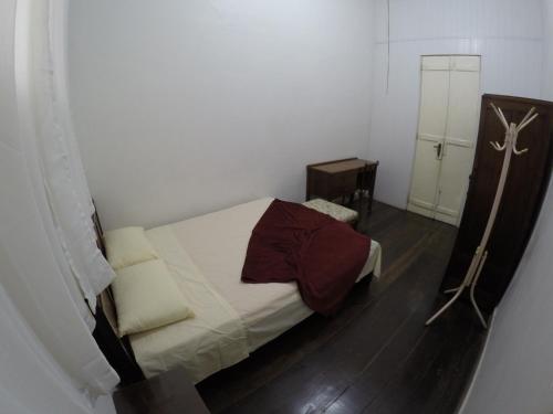 a small bedroom with a bed and a mirror at Aldeia Hostel in Manaus