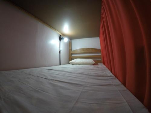 a bedroom with a bed with a red curtain at Aldeia Hostel in Manaus
