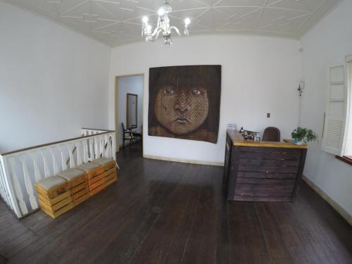 a living room with a painting of a face on the wall at Aldeia Hostel in Manaus