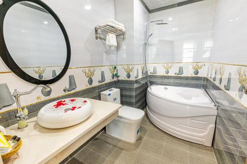 een badkamer met een toilet, een wastafel en een spiegel bij An loc hotel in Diện Biên Phủ